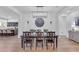 Dining room with wood floors, a large clock, and seamlessly connected to the modern kitchen at 2459 E Lindrick Dr, Gilbert, AZ 85298
