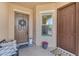 Inviting front porch featuring a decorative wreath, potted flowers, and cozy seating area for relaxing at 2459 E Lindrick Dr, Gilbert, AZ 85298