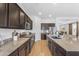 Beautiful kitchen featuring dark cabinetry, granite countertops, and stainless steel appliances at 2459 E Lindrick Dr, Gilbert, AZ 85298