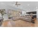 Open-concept living room featuring a comfortable sectional couch, hardwood flooring, and a view into the kitchen at 2459 E Lindrick Dr, Gilbert, AZ 85298