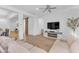 Spacious living room with wood floors, large TV, and sliding barn door to another room at 2459 E Lindrick Dr, Gilbert, AZ 85298