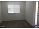 Neutral painted bedroom with wood look floors and a large window at 25744 W Winston Dr, Buckeye, AZ 85326