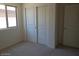 Carpeted bedroom with a window and a sliding door closet at 25744 W Winston Dr, Buckeye, AZ 85326