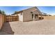 View of stucco home exterior, rock groundcover backyard and fenced perimeter at 25960 W Tonto Ln, Buckeye, AZ 85396