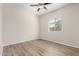 This bedroom includes a ceiling fan, wood floors and a bright window at 25960 W Tonto Ln, Buckeye, AZ 85396