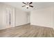 Spacious living room with wood floors, a ceiling fan, and lots of natural light at 25960 W Tonto Ln, Buckeye, AZ 85396