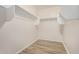 Walk-in closet with wood floors, neutral walls and shelves for added storage at 25960 W Tonto Ln, Buckeye, AZ 85396