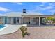 Backyard exterior view featuring a covered patio area, gravel landscaping, and an inviting swimming pool at 2911 E Leland St, Mesa, AZ 85213