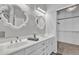 Bright bathroom featuring double sinks, white cabinets, and decorative mirrors at 2911 E Leland St, Mesa, AZ 85213