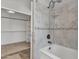 Bright bathroom featuring a shower over tub, tiled walls, and a walk-in closet at 2911 E Leland St, Mesa, AZ 85213