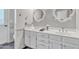 Bright bathroom featuring double sinks, white cabinets, and decorative mirrors at 2911 E Leland St, Mesa, AZ 85213