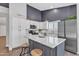 Modern kitchen featuring white cabinets, stainless steel appliances, and a marble-topped island with seating at 2911 E Leland St, Mesa, AZ 85213