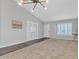 Well-lit living room featuring a vaulted ceiling, unique chandelier, and tile-to-carpet flooring at 2911 E Leland St, Mesa, AZ 85213