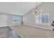 Bright living room features vaulted ceilings, neutral decor, shuttered windows, and tile-to-carpet flooring at 2911 E Leland St, Mesa, AZ 85213