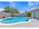 Backyard view with a sparkling blue pool and spa surrounded by lush landscaping, perfect for relaxation and recreation at 2911 E Leland St, Mesa, AZ 85213