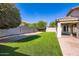 Backyard features brick pavers and artificial grass surrounded by a block wall at 29688 W Indianola Ave, Buckeye, AZ 85396
