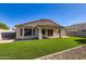 The spacious backyard features a covered patio and well-manicured artificial grass at 29688 W Indianola Ave, Buckeye, AZ 85396