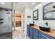 Modern bathroom featuring dual sinks, walk-in shower, and a closet at 29688 W Indianola Ave, Buckeye, AZ 85396