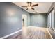 Open living room with hardwood floors, ceiling fan, and neutral walls at 29688 W Indianola Ave, Buckeye, AZ 85396