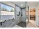Walk-in shower with gray tiling, shower niche, and glass enclosure at 29688 W Indianola Ave, Buckeye, AZ 85396