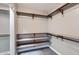 Walk-in closet with built in shelving and metal hanging rods at 29688 W Indianola Ave, Buckeye, AZ 85396