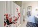 A bathroom with a shower and tub covered by a curtain with red accents at 30186 W Pinchot Ave, Buckeye, AZ 85396