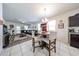 Open-concept dining area adjacent to living room, featuring updated chandelier and bar area at 30186 W Pinchot Ave, Buckeye, AZ 85396