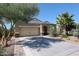 Inviting single-story home featuring a well-manicured desert landscape, complemented by a two car garage and a charming facade at 30186 W Pinchot Ave, Buckeye, AZ 85396