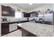 Modern kitchen boasting granite countertops, stainless steel appliances, dark cabinetry, and tile flooring, a chef's delight at 30186 W Pinchot Ave, Buckeye, AZ 85396