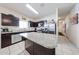 Spacious kitchen featuring dark cabinetry, granite countertops, stainless steel appliances and tile flooring at 30186 W Pinchot Ave, Buckeye, AZ 85396