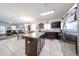 Modern kitchen with granite counters, stainless steel appliances, and tile flooring that opens to a connected dining and living space at 30186 W Pinchot Ave, Buckeye, AZ 85396