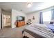 The main bedroom has a carpet, a window with blue curtain, as well as wood furniture and a TV at 30186 W Pinchot Ave, Buckeye, AZ 85396