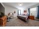 This main bedroom features a carpet, two windows with blue curtains, and wood furniture at 30186 W Pinchot Ave, Buckeye, AZ 85396