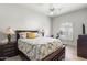 Comfortable bedroom with neutral walls, a patterned bedspread, and a sunny window at 3146 E Maryland Ave, Phoenix, AZ 85016