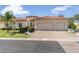 An inviting home exterior featuring a three-car garage, lush landscaping, and a stylish red tile roof at 3146 E Maryland Ave, Phoenix, AZ 85016