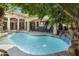 Backyard pool featuring a rock waterfall and outdoor seating area beneath lush palm trees at 3146 E Maryland Ave, Phoenix, AZ 85016