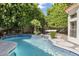 Inviting blue pool with waterfall feature, palm trees, and hammock in the backyard at 3146 E Maryland Ave, Phoenix, AZ 85016