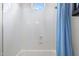 Shower featuring round window, white shower walls, and blue shower curtain at 3146 E Maryland Ave, Phoenix, AZ 85016