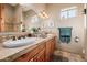 Bathroom featuring a double sink vanity with travertine countertops and decorative mirrors at 38106 N 2Nd Ln, Phoenix, AZ 85086