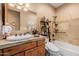 Bathroom featuring a decorative mirror and travertine countertops, along with a tub and shower at 38106 N 2Nd Ln, Phoenix, AZ 85086