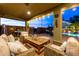Relaxing covered patio featuring comfortable seating, a built-in grill, and views of the backyard pool at 38106 N 2Nd Ln, Phoenix, AZ 85086