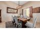 Dining room with rustic wood table, upholstered chairs, and modern lighting at 38106 N 2Nd Ln, Phoenix, AZ 85086