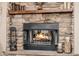 Stone fireplace with burning logs and glass enclosure adds cozy charm to the home at 38106 N 2Nd Ln, Phoenix, AZ 85086