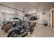 Spacious garage with multiple motorcycles, storage racks, and a seating area at 38106 N 2Nd Ln, Phoenix, AZ 85086
