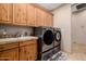 Bright laundry room with front-loading washer and dryer, cabinetry and tile flooring at 38106 N 2Nd Ln, Phoenix, AZ 85086