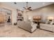 Open living room with stone fireplace, ceiling fan and travertine floors at 38106 N 2Nd Ln, Phoenix, AZ 85086