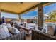 Cozy covered patio with outdoor kitchen, grill, comfortable seating, and views of the pool and blue skies at 38106 N 2Nd Ln, Phoenix, AZ 85086