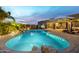 Lush backyard with a sparkling pool, rock waterfall, and inviting patio furniture for outdoor entertaining at 38106 N 2Nd Ln, Phoenix, AZ 85086