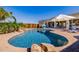 Stunning backyard featuring a freeform pool, waterfall, stone accents, lush palm trees and desert landscaping at 38106 N 2Nd Ln, Phoenix, AZ 85086