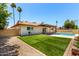 Inviting backyard featuring artificial grass, a refreshing pool, and a covered patio area at 3913 N 86Th St, Scottsdale, AZ 85251